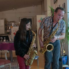 Father and daughter playing sax